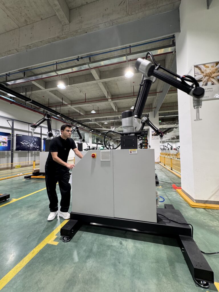 Fotos de Léo Mello com robôs colaborativos no corredor da fábrica da CetroX na China.