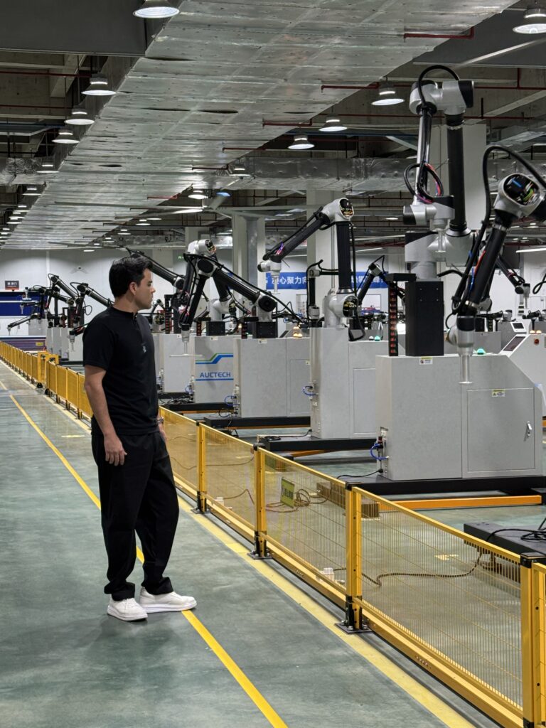 Fotos de Léo Mello com robôs colaborativos no corredor da fábrica da CetroX na China.