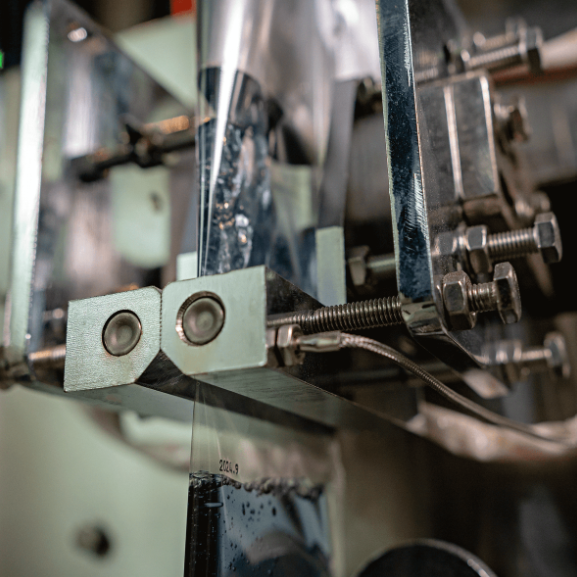 Fotografias da Empacotadora Automática de Sachês para Líquidos CAPM 200 VP-100 RK da CetroX e de sachês embalados por ela.
