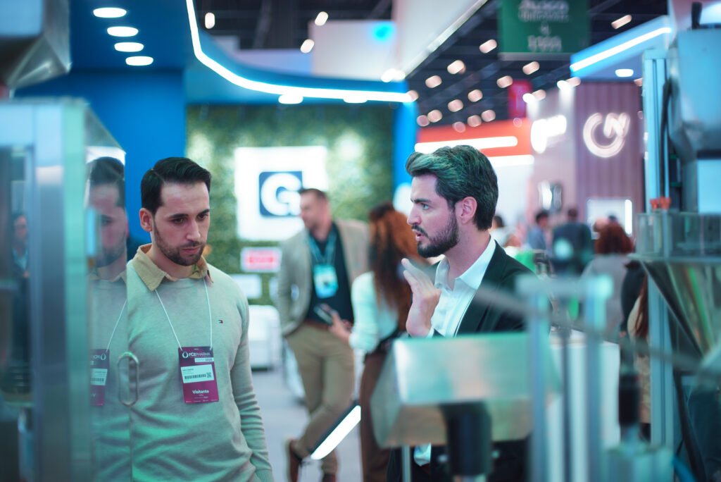 Fotografias das máquinas da CetroX no estande da FCE Pharma e dos vendedores em atendimento no evento.