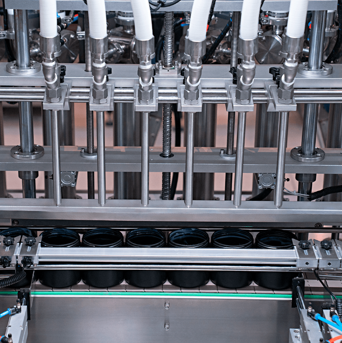Fotografias da Envasadora Automática de Pastosos Servomotorizada CAFM VP-1000 6N SM envasando cosméticos em potes.