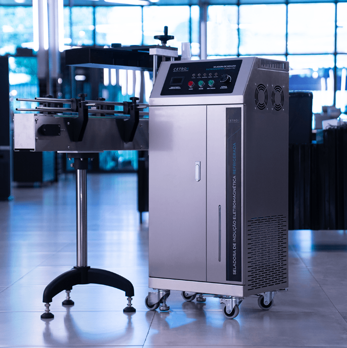 Seladora de Indução Eletromagnética Refrigerada com Esteira CASM I-150 da Cetro e um frasco selado por ela.