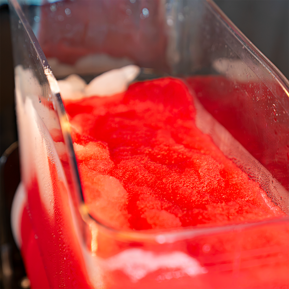 Reservatório da Máquina de Raspadinha e Bebidas Congeladas Slush e diferentes raspadinhas decoradas em copos de vidro e plástico.